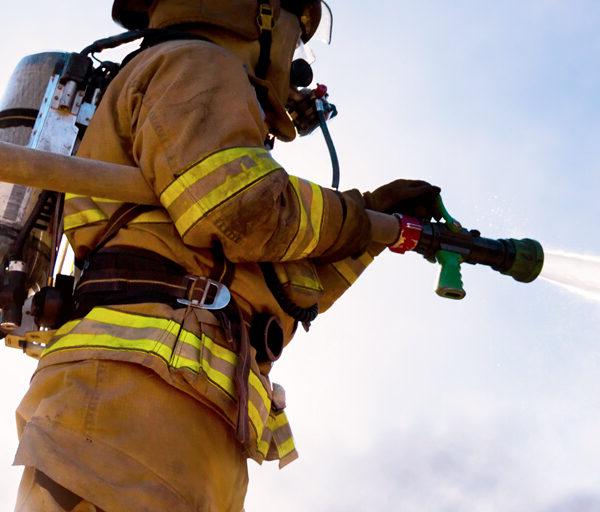 firefighter using a water hose